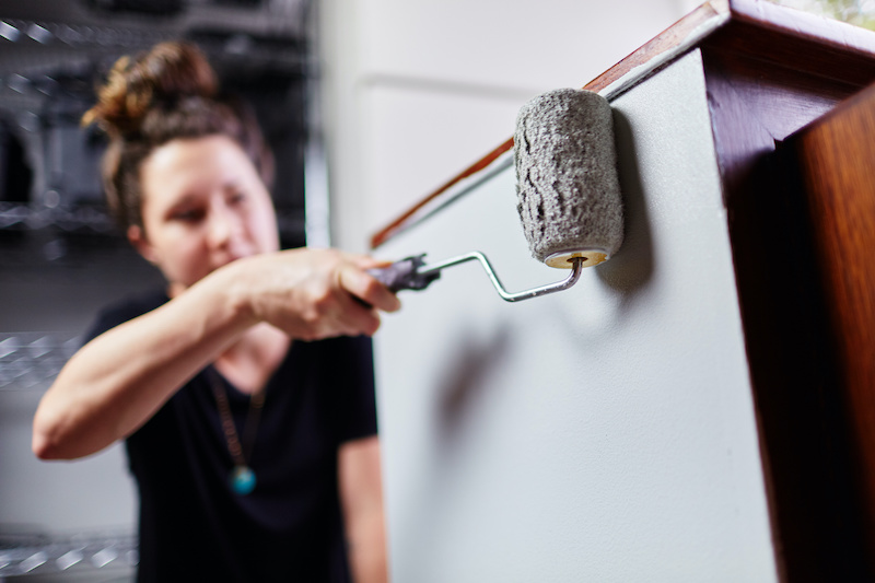 woman painting cabinets